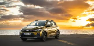 Golden SUV parked on a coastal road at sunset with the sea and orange sky in the background.