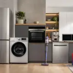 Electrocasnice Resigilate la eMAG, REDUCERI de 2.599 LEI la Produse Samsung, LG, Beko, Arctic, Whirlpool, Bosch | iDevice.ro Modern kitchen with stainless steel appliances, wooden countertops, and EMAG boxes on the floor.