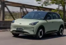 Geely E2 ATACA DACIA Spring 2 cu un Pret Surprinzator de MIC si Dotari Impresionante Front-left three-quarter view of a pale green Geely EX2 electric SUV driving on a road.