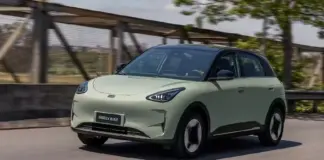 Front-left three-quarter view of a pale green Geely EX2 electric SUV driving on a road.