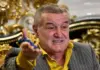 Gigi Becali a CLACAT În Direct după Rușinea FCSB cu Auda (VIDEO) Man in a pinstripe suit and yellow shirt gesturing as he speaks in a lavish, gold-adorned room.