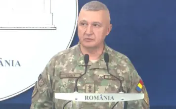Situația CRITICĂ la Granița României, AVERTISMENTUL de ULTIMĂ ORĂ al Șefului Armatei Military officer in camouflage speaking at a podium during a briefing, with a blue backdrop and 'ROMÂNIA' visible on the sign.