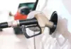 Gas pump nozzle inserted into a car fuel tank during refueling at a station