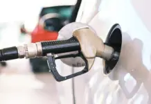 Benzina și Motorina la 10 LEI din Cauza Războiului din Iran, Guvernul e Legat de Mâini Gas pump nozzle inserted into a car fuel tank during refueling at a station