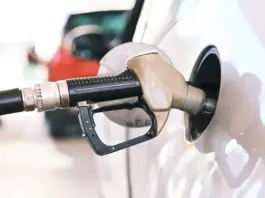 Gas pump nozzle inserted into a car fuel tank during refueling at a station
