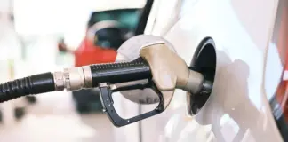 Gas pump nozzle inserted into a car fuel tank during refueling at a station