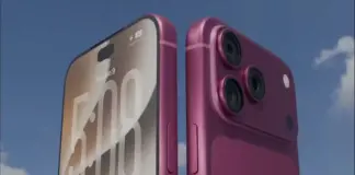 Close-up of a pink iPhone showing its triple-camera rear array against a clear blue sky, outdoors.