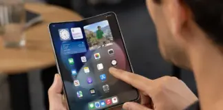 Person holds a tablet displaying app icons on the home screen with a photo widget.