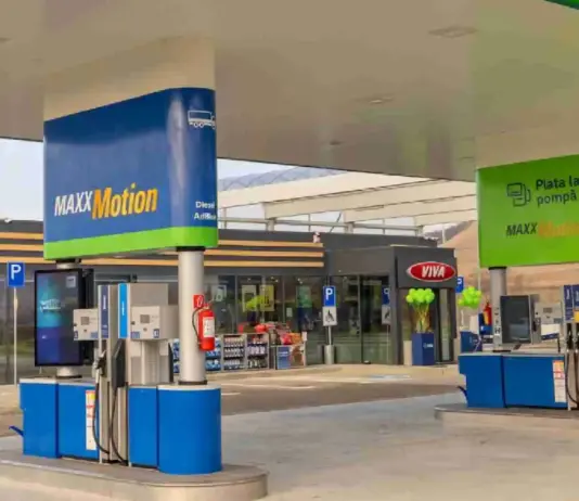 Fuel pumps under a white canopy at a MAXXMotion gas station with blue and green branding.
