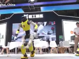 Yellow humanoid robot performs on a stage in Shanghai, China, with spectators and other robots nearby. (Informative caption: 'Shanghai, China' visible on stage)
