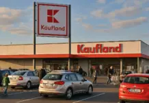 Catalog Kaufland cu Ofertele din Magazine pe 5 August 2026 pentru Card XTRA Kaufland supermarket exterior with a large red Kaufland sign and a parking lot in the foreground during daylight.