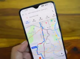 Hand holds a smartphone showing a navigation app with colored routes and travel times on a city map