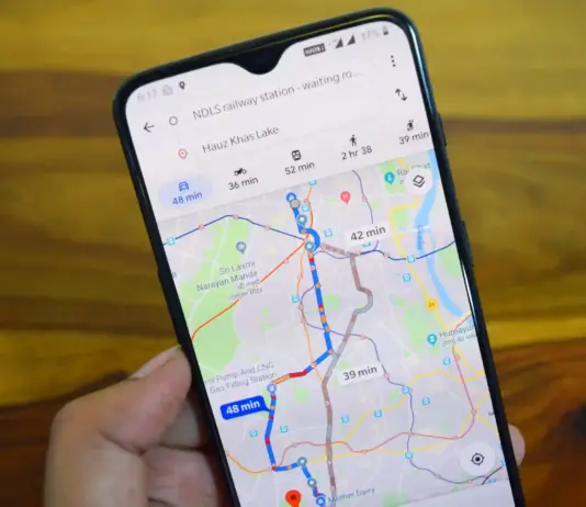 Hand holds a smartphone showing a navigation app with colored routes and travel times on a city map