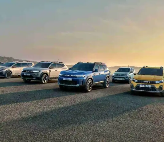 Row of modern SUVs lined up on a gravel surface at sunset, with mountains in the distance on the left.