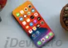 iPhone 20 Pro: Schimbarile Complet Neasteptate Dezvaluite Close-up of a smartphone displaying a colorful home screen with many app icons on a light desk surface, angled from above.