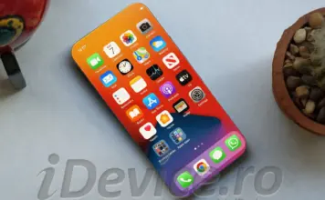 iPhone 20 Pro: Schimbarile Complet Neasteptate Dezvaluite Close-up of a smartphone displaying a colorful home screen with many app icons on a light desk surface, angled from above.